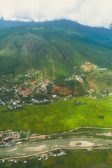 Fototapeta na wymiar Mountainous landscape shot Aerial view of settlement and vegetation in Bhutan