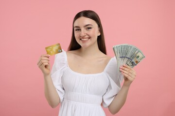 Happy woman with credit card and dollar banknotes on pink background