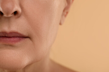 Woman with normal skin on beige background, macro view. Space for text © New Africa