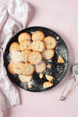 Homemade biscuits on delicate pink background.  Some ingredients are: eggs; sugar; flour; butter. Top view.