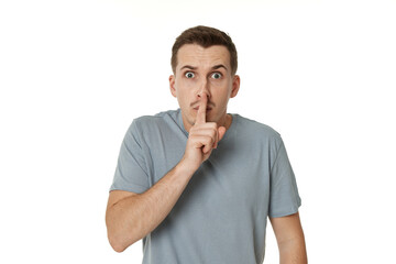 Young man showing sign of silence gesture on white background
