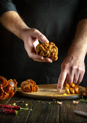 Cooking coffins by chef hands on kitchen table in tavern. Mushroom diet concept.