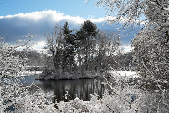 Snowy winter landscape by a lake with a litte island in the lake 