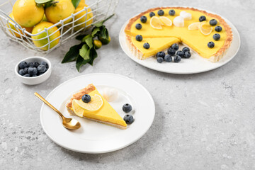 A slice of lemon pie with blueberries on a white plate.