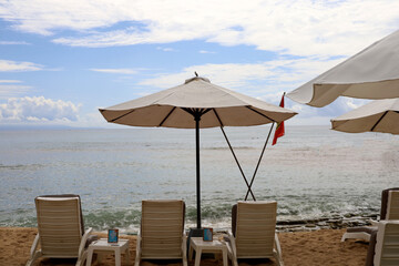 beach chairs, white beach lounge benches on the sand with blue sky background, summer vacation concept at the beach.