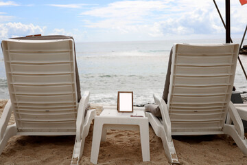 beach chairs, white beach lounge benches on the sand with blue sky background, summer vacation concept at the beach.