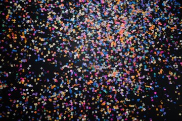 Fototapeta na wymiar Vivid confetti pieces create a dynamic cascade on a black backdrop, ideal for celebrations. Colorful Confetti Cascade in Black Space