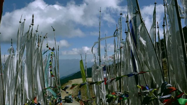 Fluttering Manidhar flags. Manidhar are tall white prayer flags vertically attached to the poles. They are raised after a person has died as a remembrance for the deceased.