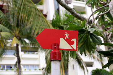 Tsunami warning board on the beach, outdoor tsunami sign with directional arrows and evacuation...