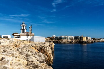 Fototapeta na wymiar view of the Ciutadella llighthouse and Sant Nicolau Castle at the harbour entrance in Ciutadella