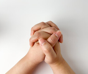Light skin toned human clasped hand pose isolated on white studio background. Hope, peace, and...