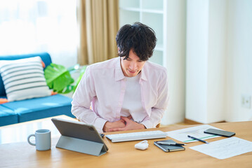 腹痛に苦しむ若い男性