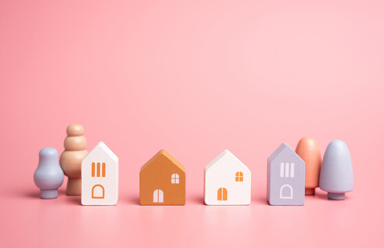 Houses and figures, children toys. Buying a home, searching for rent. Investments in real estate. Figures of houses and trees in a small neighborhood. Safety and integrity.