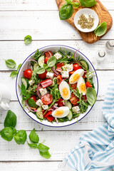 Egg and arugula fresh vegetable salad with feta cheese, top view