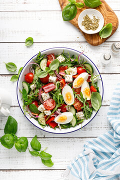 Egg and arugula fresh vegetable salad with feta cheese, top view