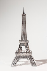 Fototapeta na wymiar Delicate metal Eiffel Tower model on white background