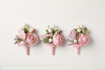 Beautiful boutonnieres on white background, flat lay © New Africa