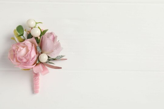 Beautiful boutonniere on white background, top view. Space for text
