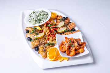 seafood mixture on a white grill. Delicious grilled fish, shrimp in sauce and salmon on the table