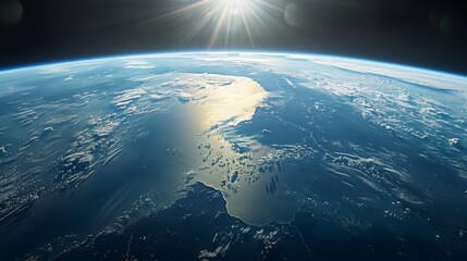 The sun rises over the Earth's curvature, illuminating the planet's varied terrain and vast oceans from space.