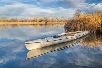 decked expedition canoe on a calm lake in northern Colorado, winter scenery without snow