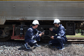 maintenance and technician railway checking the power train of oil cargo train and the railway work on railroad station with tablet.
