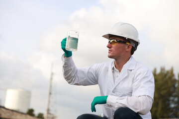 Male  biologist taking a water sample from factory 
