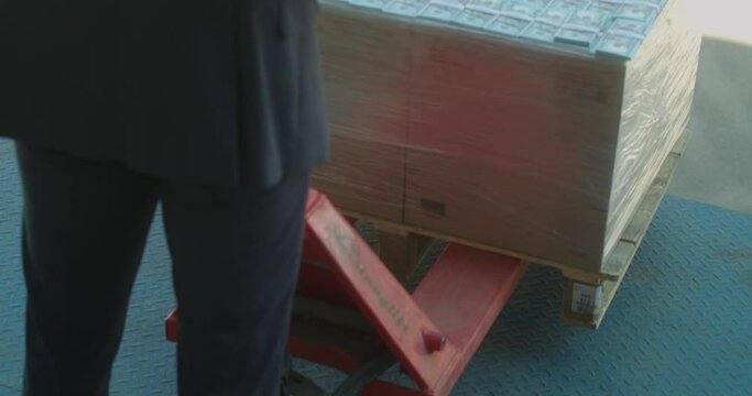 A man is loading a pallet of dollars in 4k