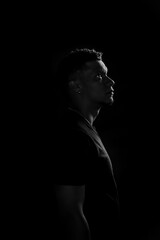 Low key of young African American man in profile. black and white photography