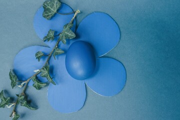 Easter decoration in blue color with eggs and paper flowers 