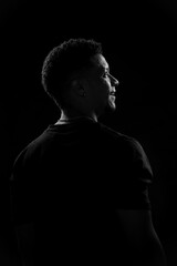 Low key of young Brazilian man in profile. black and white photography