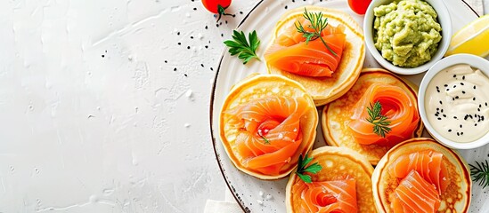 Mini blini pancakes with soft cheese cold smoked salmon and guacamole. with copy space image. Place for adding text or design