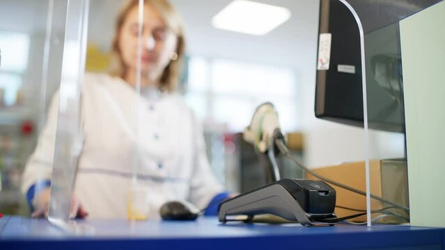 Close-up of paying for medicine by phone in a pharmacy. An employee in a medical gown is waiting for the transaction to be confirmed. High quality 4k footage