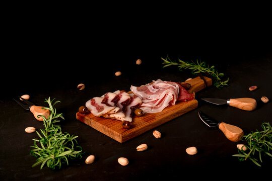 Italian specialties, Speck and Guanciale on a black background.
Guanciale pork from the cheek part. 


