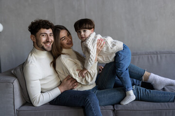 Happy family lying on their sofa at home