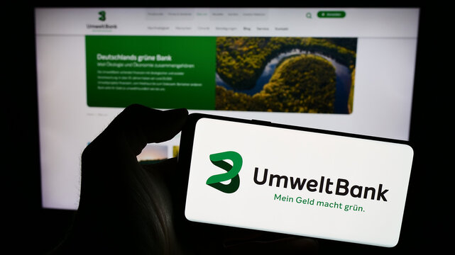 Stuttgart, Germany - 02-12-2024: Person holding smartphone with logo of German financial services company Umweltbank AG in front of website. Focus on phone display.