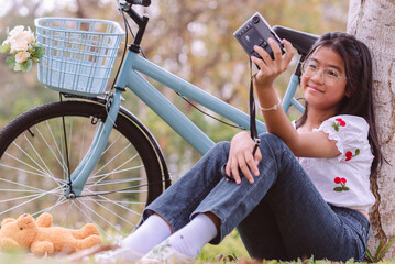 Teenage Asian girl wearing eyeglasses and a white shirt sitting smile enjoy with take camera under...