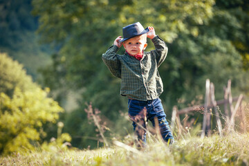 Cute Little Happy Boy with Hat and Bandana in Green Summer Forest - 741649527