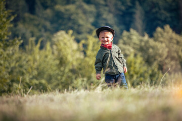 Cute Little Happy Boy with Hat and Bandana in Green Summer Forest - 741651166
