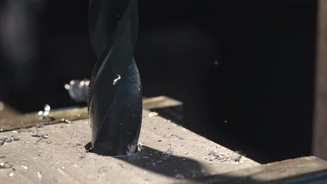Explore the elegance of metal drilling in slow motion, capturing the graceful motion of the drill as it creates precise holes in iron.