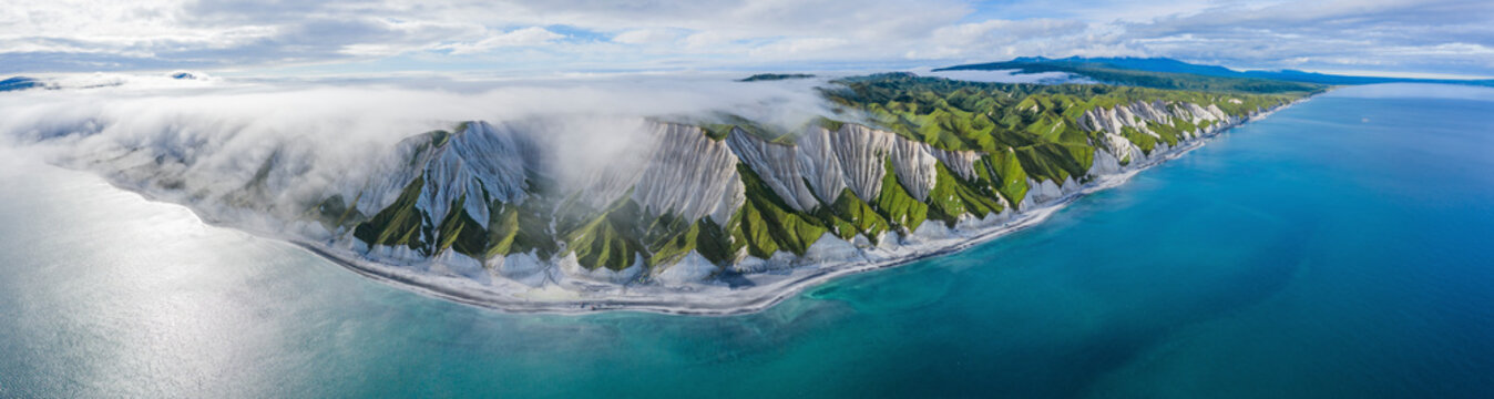 Aerial panoramic view of Iturup Island along Sea of Okhotsk coastline, Kuril Archipelago, Sakhalin Oblast, Russia.