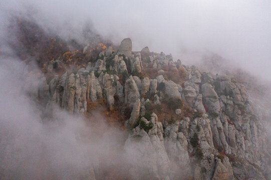 Aerial view of a mountain landscape with low clouds and fog at sunset in Crimea Region, Autonomous Republic of Crimea, Ukraine.