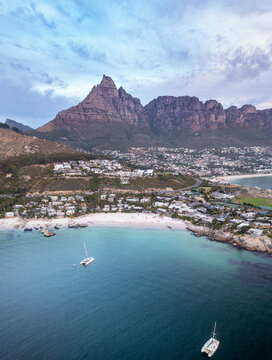 Aerial view of yachts moored in a bay with white sandy beaches and boulders and mountains in the background, and houses in the landscape Cape Town, Western Cape, South Africa.