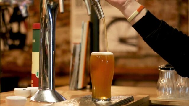Sirviendo cerveza tirada artesanal. Llenando vaso de cerveza tirada artesanal. Pinta de cerveza artesanal derramando espuma