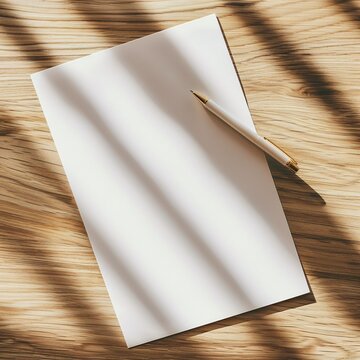 In the high-angle view, a pen rests beside a blank sheet of paper on the table, their presence suggesting the potential for creation and expression. The expanse of untouched paper offers endless.