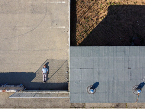 Aerial view of a person laying down in a parking lot Serravalle, Scrivia, Piedmont, Italy.