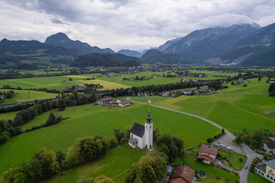 Aerial drone view of Wallfahrtskirche St. Nikolaus with Golling an der Salzach in background at cloudy day, Golling an der Salzach, Salzburg, Austria.