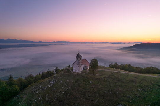 Aerial drone view of Cerkev sv. Ane church on hill at Jezero, Brezovica, Slovenia.