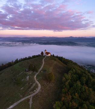 Aerial drone view of Cerkev sv. Ane church on hill at Jezero, Brezovica, Slovenia.