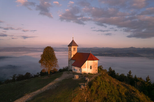 Aerial drone view of Cerkev sv. Ane church on hill at Jezero, Brezovica, Slovenia.